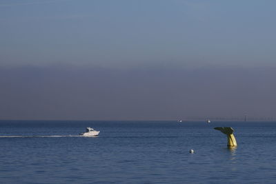 People in sea against clear sky