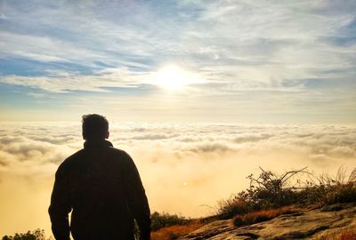 Rear view of man looking at sunset