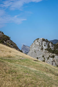 Scenic view of land and mountains against blue sky