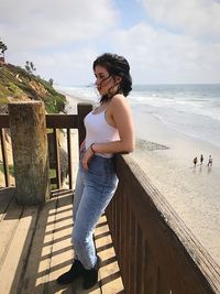 Young woman standing against sea at beach