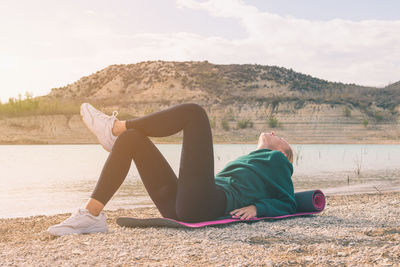 Side view of woman sitting on field