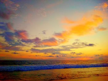 Scenic view of sea against dramatic sky during sunset