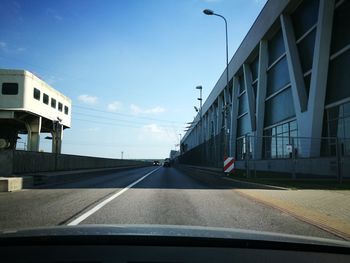 Cars on road against sky in city