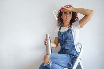 Portrait of girl sitting against wall