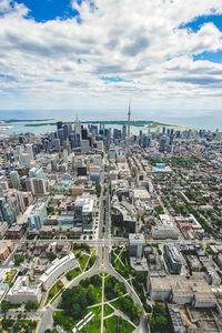 Aerial view of cityscape against cloudy sky