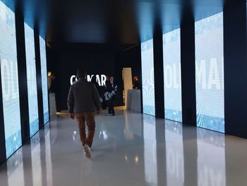 Rear view of people walking in corridor of building