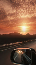 Close-up of car on road against sky during sunset