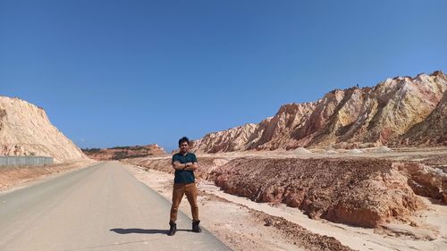 Full length of man standing on road against landscape