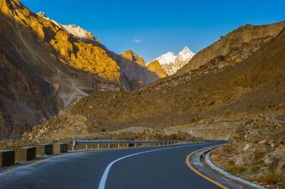 Road amidst mountains against clear sky