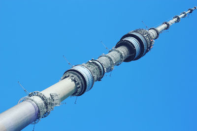 Low angle view of communications tower against blue sky