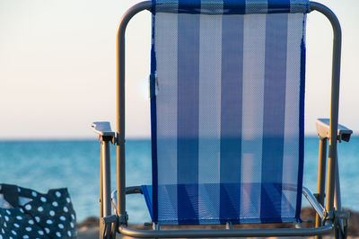 Close-up of blue chair against clear sky