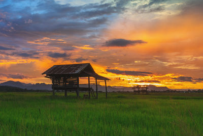 Built structure on field against sky during sunset