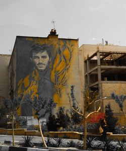 Low angle view of graffiti on building against sky