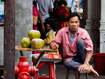 Portrait of man sitting at market stall