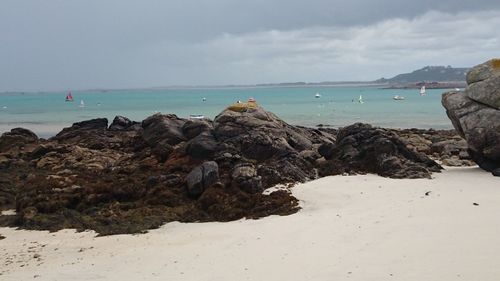 Rocks on beach against sky