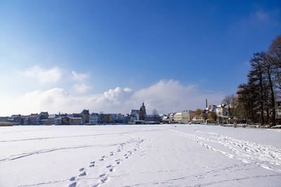 Snow covered city against blue sky