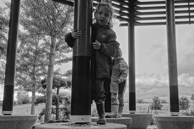 Full length of boy standing by tree