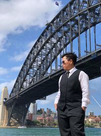 Full length of man standing on bridge against sky