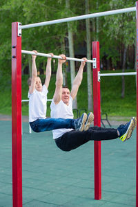 Rear view of man swinging at playground