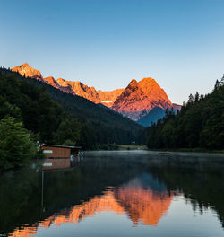 Scenic view of lake and mountains against clear sky