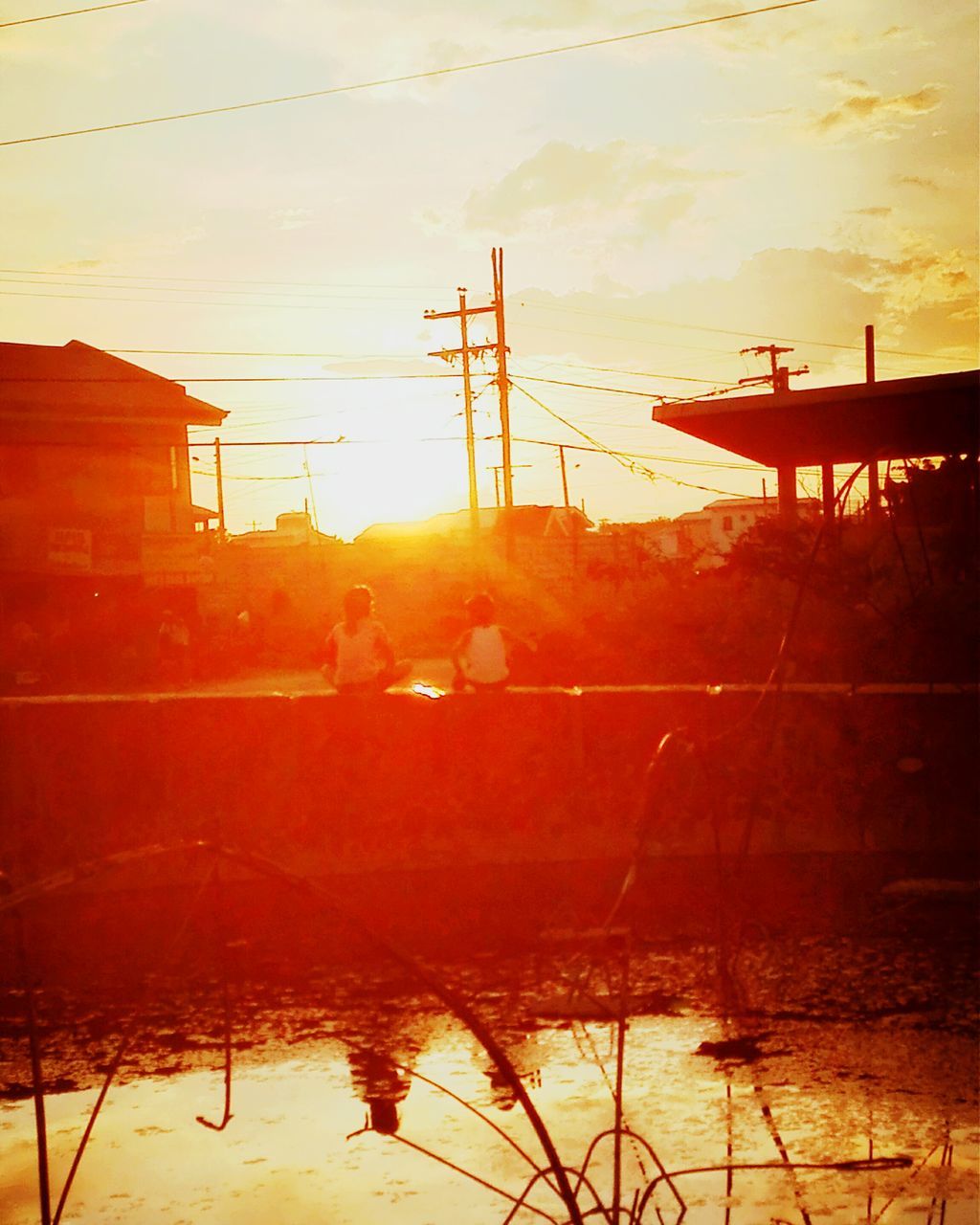 sunset, sun, water, orange color, built structure, architecture, building exterior, reflection, sky, silhouette, sunlight, nature, electricity pylon, crane - construction machinery, outdoors, beauty in nature, no people, power line, tranquility, waterfront