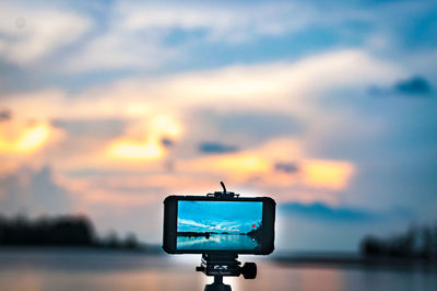 Low angle view of camera against sky during sunset