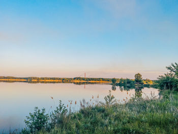 Scenic view of lake against sky at sunset