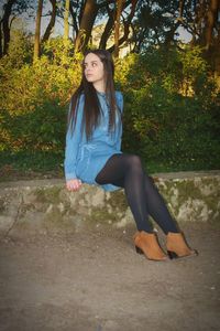 Portrait of young woman against trees