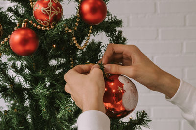 Cropped hand of woman holding christmas tree