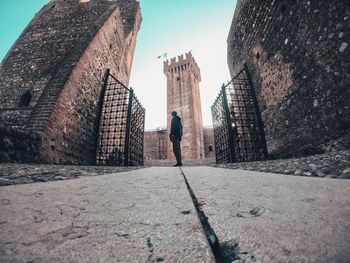 Rear view of man and buildings against sky