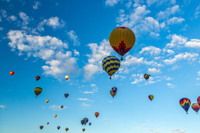 Low angle view of hot air balloons flying against sky