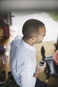 High angle view of businessman holding coffee cup in portable office truck