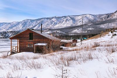 Snow covered landscape and mountains against sky