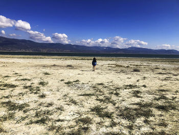 Rear view of woman walking at beach