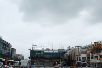 Buildings in city against cloudy sky