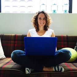 Portrait of young man sitting on wall