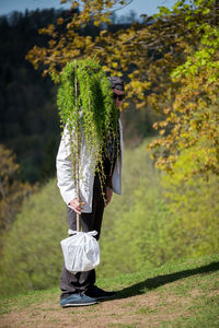 Full length of man with plants standing on field