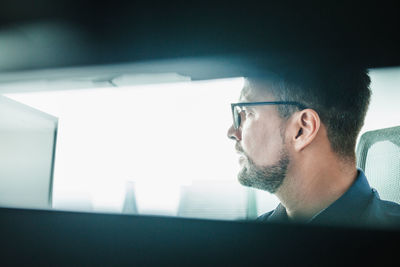 Low angle view of man looking through window