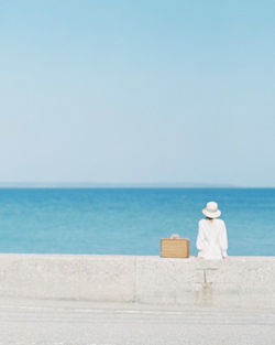 Rear view of man looking at sea against sky