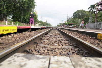 Railroad tracks by trees against sky