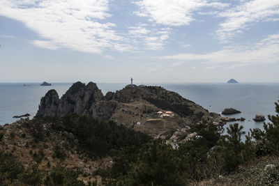 Scenic view of sea by cliff against sky