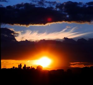 Silhouette cityscape against sky during sunset