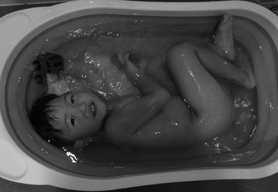 High angle portrait of smiling boy in bathroom