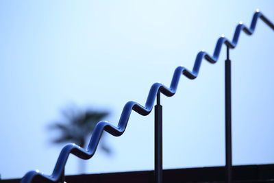 Close-up of metal wire against clear blue sky