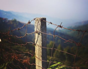 Low angle view of barbed wire against sky