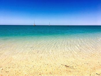 Scenic view of sea against clear blue sky