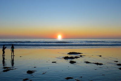 Scenic view of sea against clear sky during sunset