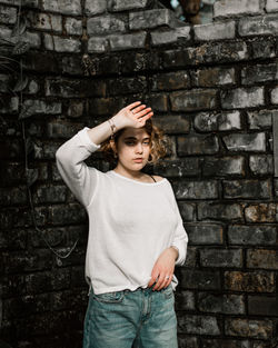 Portrait of woman standing against wall