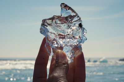 Close up man holding ice on beach concept photo