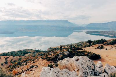 Scenic view of sea and mountains against sky